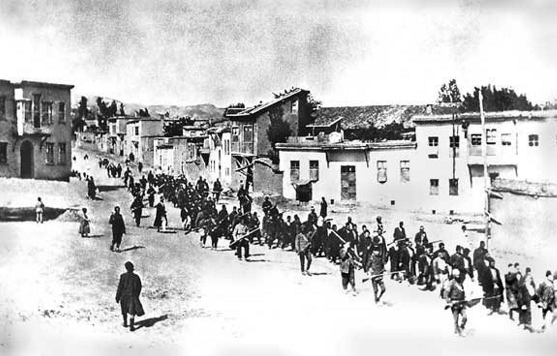 Turkish soldiers with bayonets fixed escort Armenian men from the town of Kharpert (or Harput) to their execution.
